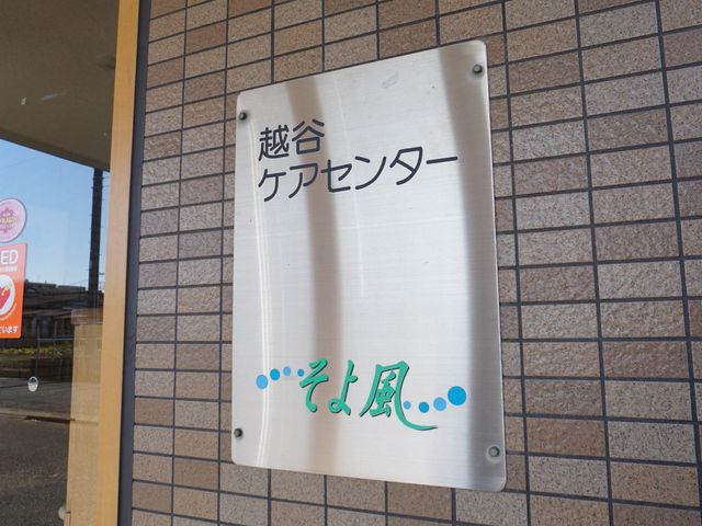 看板のクローズアップ ロゴ 外壁に掲げられた清潔感のある看板です。明瞭なデザインで、来訪者を温かくお迎えしています。