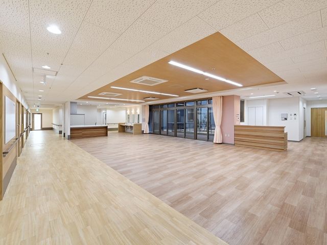 明るい広々共有スペース 食堂 ゆったりとした空間の多目的室です。天井が高く、木目調の床が温かみのある雰囲気を醸し出しています。