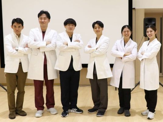 白衣のスタッフが並ぶ多目的室  