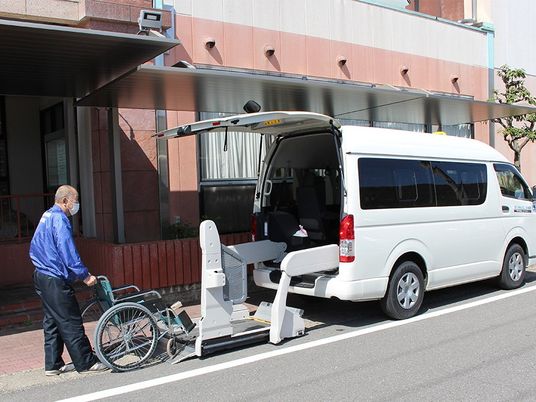 車いす送迎車と職員の外観  