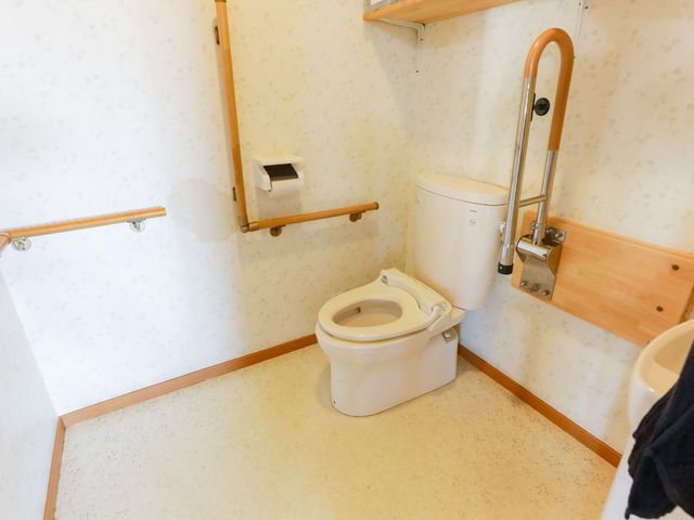 バリアフリー設計のトイレ トイレ 手すり完備の清潔な空間で、利用者の快適さに配慮した造りです。