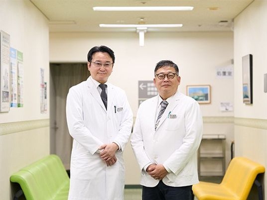 白衣の男性2人が並ぶ廊下  