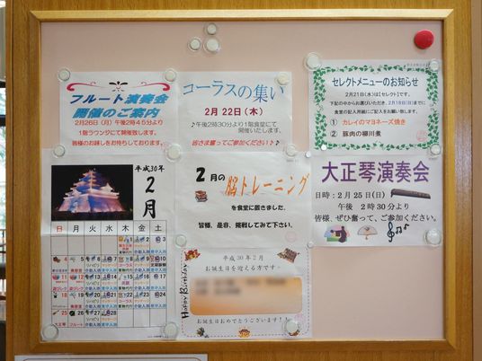 レクリエーションの日時と場所が記入されたポスターが、丸い磁石で掲示されている。右上には、セレクトメニューの内容も書かれている。