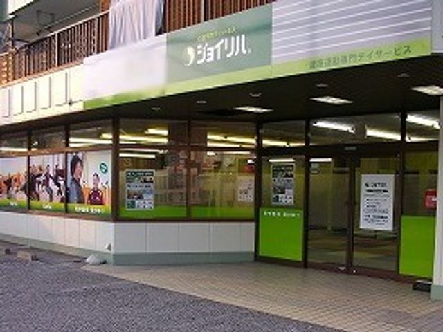 店頭の看板 看板 明るい緑色が特徴的なエントランスです。施設の名前が大きく見やすく表示されています。