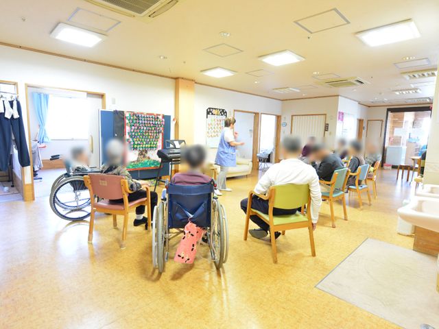 活動中の明るい多目的室 レクリエーション ゆとりある空間で様々な活動が行われる多目的室です。皆さんが集い、楽しい時間を過ごしている様子が伺えます。