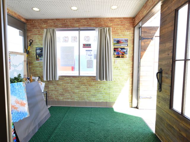 エントランスの明るい風景 エントランスホール 採光豊かなエントランスで、心地よい日差しを感じながら出勤できます。木目調とレンガの壁が暖かみのある空間を演出しています。