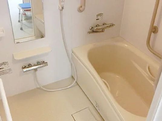 浴槽と手すりのある浴室  