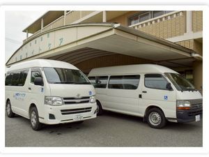 送迎車が並ぶ建物外観  