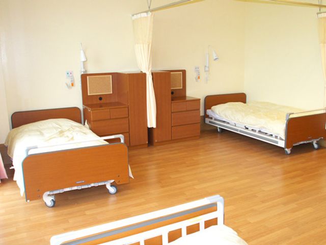 広々とした居室 居室 木製の床とベッドが並ぶ、落ち着いた雰囲気を感じる空間です。カーテンで仕切られたプライベートな環境も魅力です。