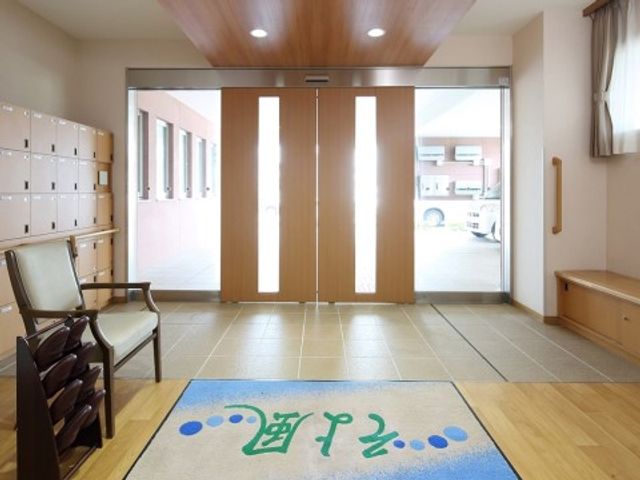 明るいエントランスの様子 エントランス 広々とした入り口は、出入りしやすい設計になっており、暖かい光が心地よく迎えてくれます。上履きが揃えられるスペースも整っており、清潔感のある印象を与えています。