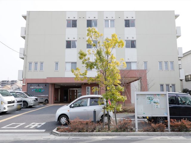 施設の外観とエントランス 外観 ゆとりのある駐車スペースが確保された建物の正面です。入口は広々としており、心地よくお出迎えいたします。