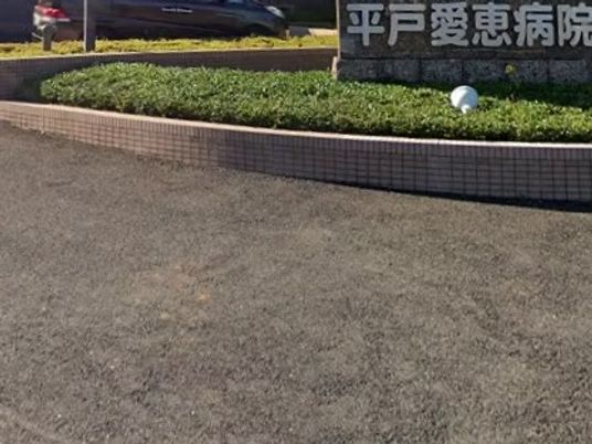 病院名の看板と植え込みの外観  