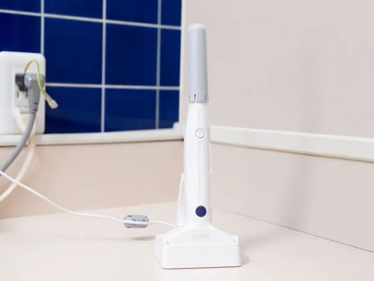 充電中の機器と壁面の洗面台  