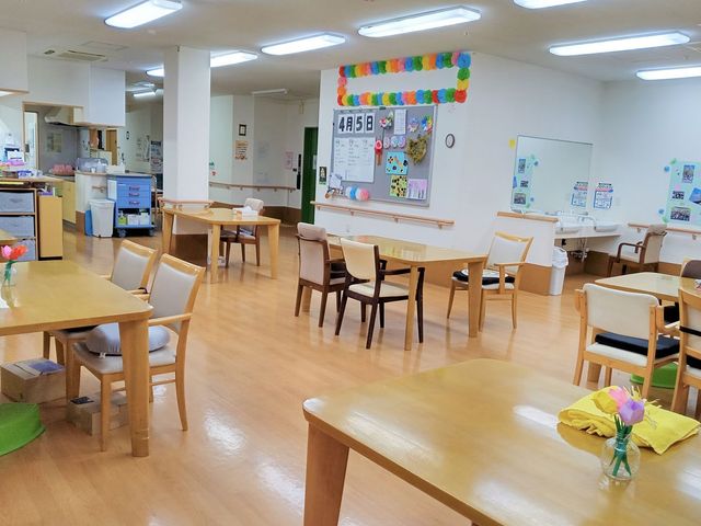 広々としたダイニングルーム ダイニングルーム 自然光が差し込む広々とした共有スペースでは、ゆったりとした時間を過ごせます。テーブルには色とりどりの花が飾られています。