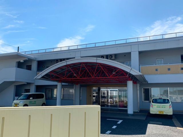 施設の正面入口 外観   青空の下に、ゆとりのある車寄せが設けられた出入口です。送迎車が停めやすく、来訪時の乗り降りも落ち着いて行えそうです。