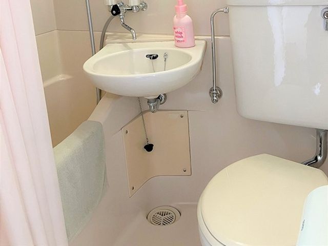 手すり付きのトイレ トイレ   手すりが設置された明るいトイレです。限られた空間でも、使いやすさに配慮したつくりが見られます。
