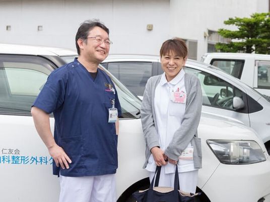 スタッフが車前で談笑する外観  