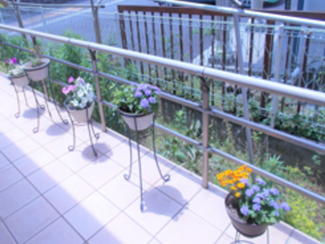 花壇が並ぶテラス テラス   手すりが設けられた明るいテラスです。鉢植えの花が並び、外の景色を眺めながら気分転換しやすそうです。