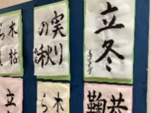 書の掲示物が並ぶ廊下 掲示物   季節の書が並び、落ち着いた雰囲気が伝わる掲示です。通るたびに目に入り、空間にやわらかさを添えています。