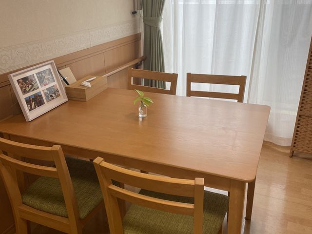 明るい食事テーブル ダイニングルーム 大きな窓から光が入る、落ち着いた食事スペースです。木のテーブルと椅子が並び、ゆっくり過ごしやすい雰囲気です。