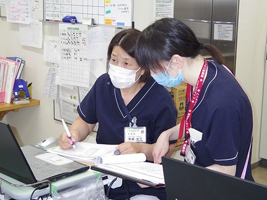 スタッフが記録確認する事務室  