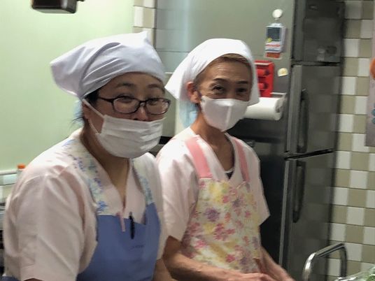 調理中の職員が並ぶキッチン  