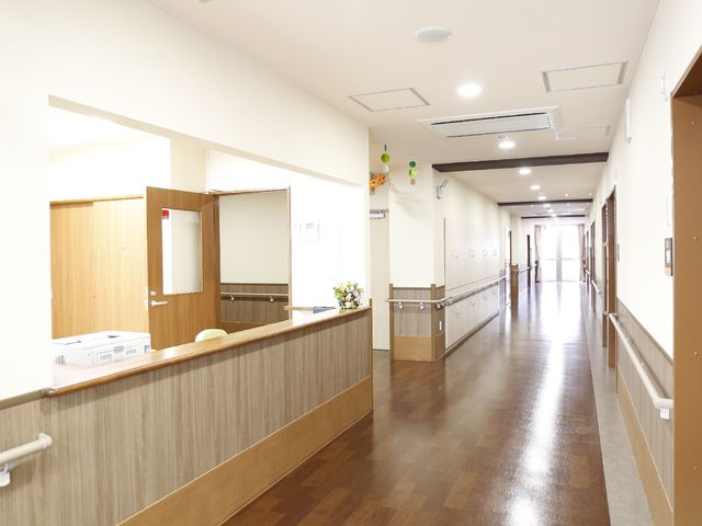 清潔な廊下の一部 快適に過ごすための手すりとエアコン 親しみやすい雰囲気の廊下は、明るく清潔感があり、床材も滑りにくい素材で安全に配慮されています。