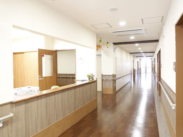 清潔な廊下の一部 快適に過ごすための手すりとエアコン 親しみやすい雰囲気の廊下は、明るく清潔感があり、床材も滑りにくい素材で安全に配慮されています。