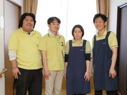 笑顔のスタッフが立つ居室