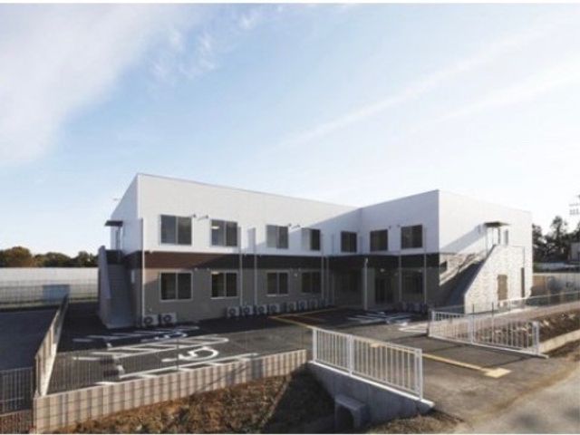 白と茶色の外観の建物 外観 広々とした駐車スペースがあり、白と茶色のモダンな建物は、明るく開放的な雰囲気を提供しています。