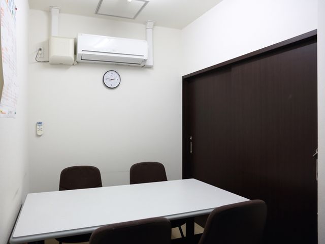 白いテーブルのある部屋 応接室 こちらはスタッフが使用する休憩室の様子です。必要な休憩時間を確保し、快適な職場環境を提供しています。