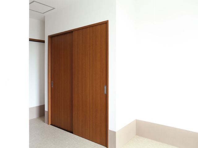 シンプルな茶色の扉 居室押入れ ゆとりを持って設計された居室入口は、安心して利用できる落ち着いた色合いです。