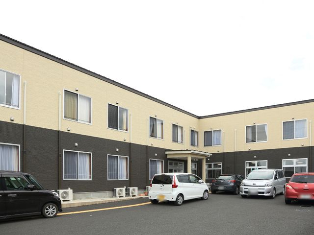 黄色い壁の建物正面 外観 清潔感のある色合いでまとめられた建物です。仕事のスタートにふさわしい、活気ある雰囲気のある場所となっています。