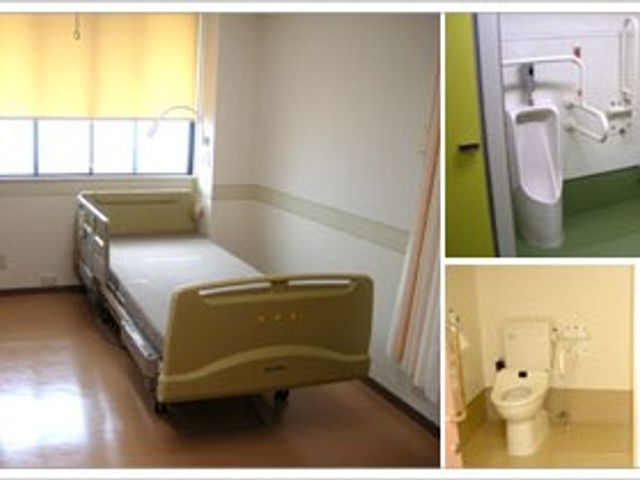 明るい居室とトイレ 居室   窓から光が入る居室で、ベッドと手すりが見えます。右側にはトイレもあり、移動しやすいつくりです。