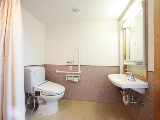 バリアフリー設計のトイレ トイレ 手すり付きで安全性に配慮されたきれいなトイレスペースです。ゆったりとした間取りで、どなたでも快適にお使いいただけます。