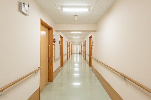 明るく清潔な廊下 廊下 手すりが設置された広々とした廊下です。壁に掲示された情報も見やすく、ゆったりとした時間が流れている様子が伝わります。