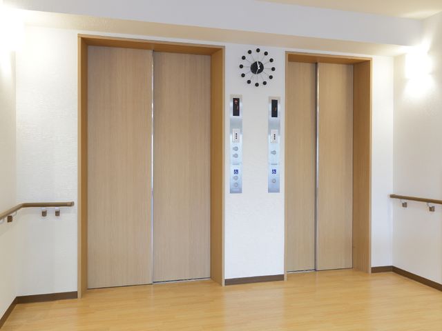 きれいなエレベーターホール エレベーター前 ゆったりとした空間のエレベーターホールは、明るく清潔感があります。手すりも備えられ、安心して移動できる造りになっています。