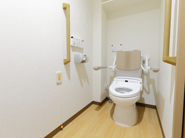 バリアフリー設計のトイレ トイレ 手すりがしっかりと取り付けられ、安全性を考慮した清潔なトイレです。利用者の快適さを第一に配慮した空間が整っています。