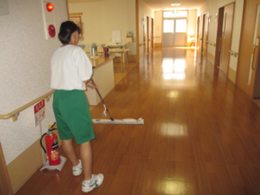 廊下を掃除する職員  