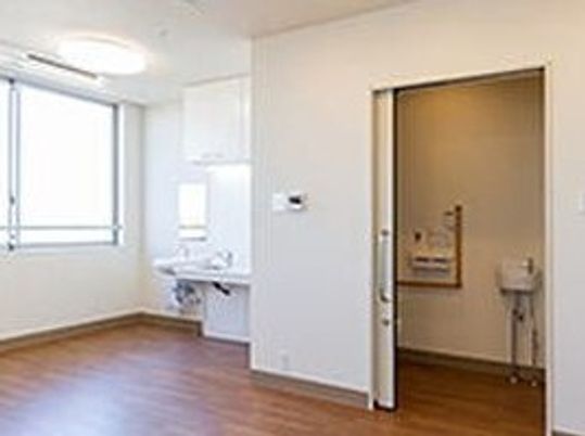 トイレや洗面台がついた施設内の居室の様子。フローリングの部屋