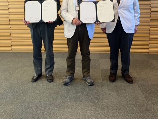 証書を持つ3人の人物の足元の内観  