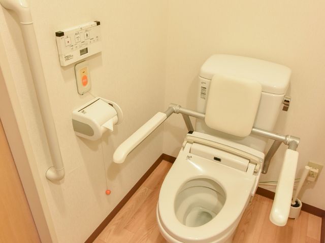 バリアフリートイレ設備 トイレ 利用者の自立を支援する設計の手すり付きトイレです。安心してご利用いただける環境が整っています。