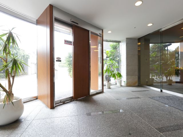 明るいエントランスの観葉植物 入り口 充実した設備が整っている開放感のあるエントランスです。植物が彩りを添え、訪れる皆様を心地よく迎え入れます。