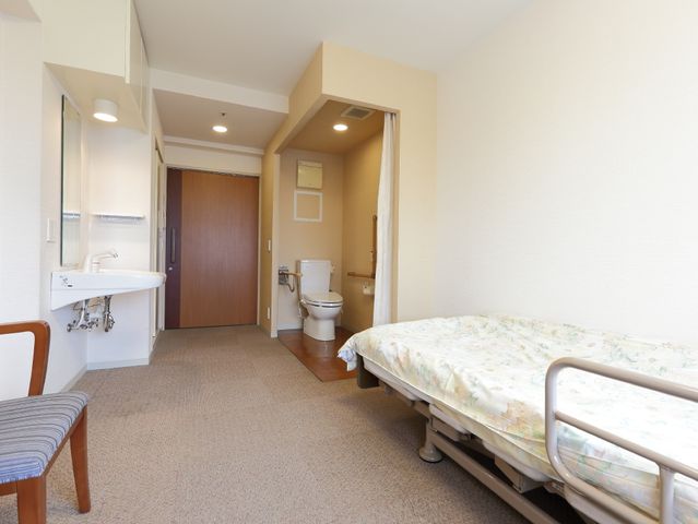 居室のベッドと洗面所 室内 清潔感のあふれる居室が整っており、快適な私空間を提供しています。個別の洗面台があり、日々の生活がより便利になっています。