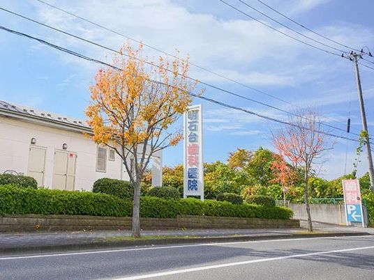 建物前の看板と木々の外観  