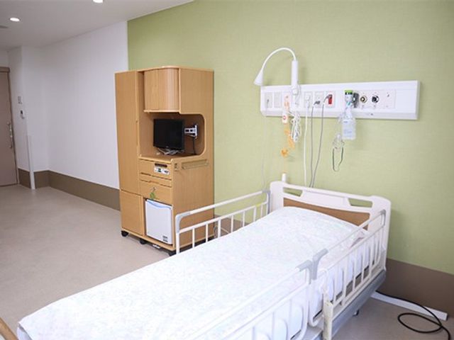 居室のベッド 居室   ベッド脇に機器が整えられた、すっきりした居室です。壁面の配線まわりも見やすく、落ち着いて過ごしやすい印象です。