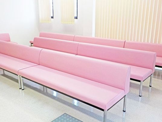 ピンクの長椅子が並ぶ待合室  