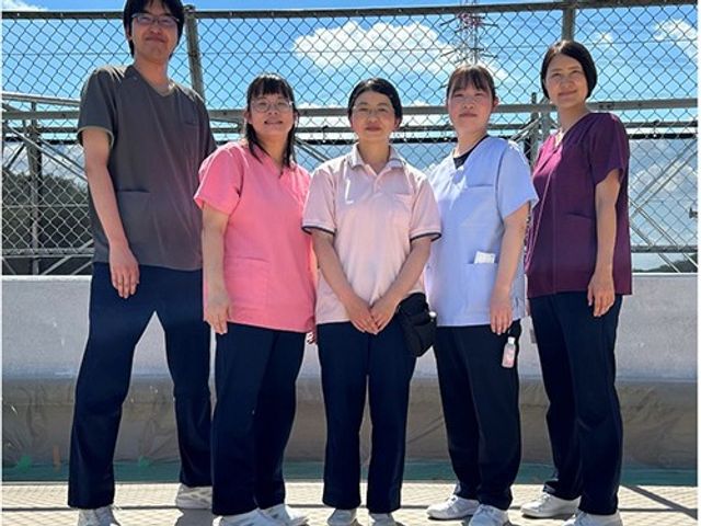 スタッフ5人の集合 スタッフイメージ   5人のスタッフが並んで立ち、笑顔で撮影に応じています。明るい雰囲気が伝わり、働く仲間の様子をイメージしやすいです。