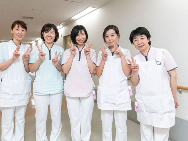 笑顔のスタッフ廊下 廊下   明るい廊下で、5人のスタッフが笑顔で並んでいます。職員同士の雰囲気が伝わり、働く様子をイメージしやすいです。