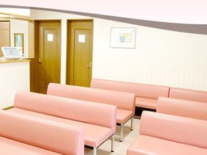 ピンクの長椅子が並ぶ待合内観  